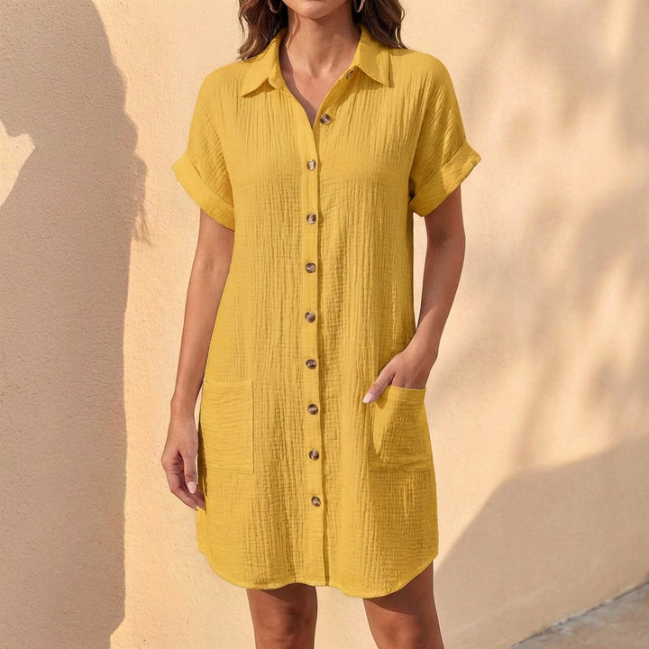 Close-up of cuffed short sleeves & button-front detail on a women's relaxed fit midi shirt dress. Summer style.