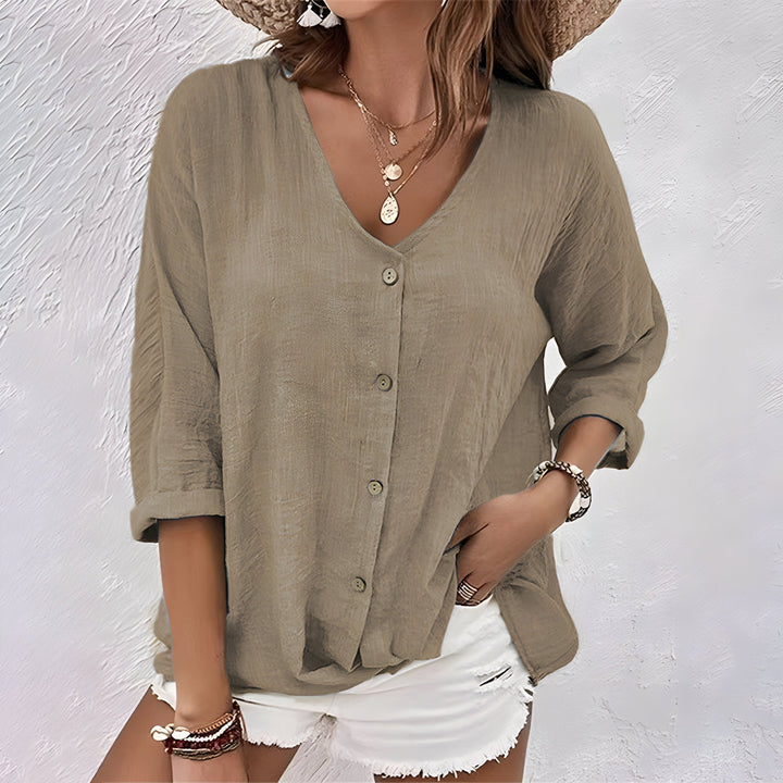 Chic women's relaxed fit blouse, V-neck, button-down front, and adjustable roll sleeves for various looks.