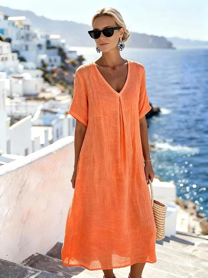 Woman wearing a flowing V-neck midi dress, short sleeves, relaxed fit, perfect for casual spring days.