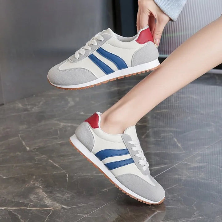 Close-up of women's retro colorblock sneakers, showing the detailed stripe pattern & white laces. Fashion footwear.