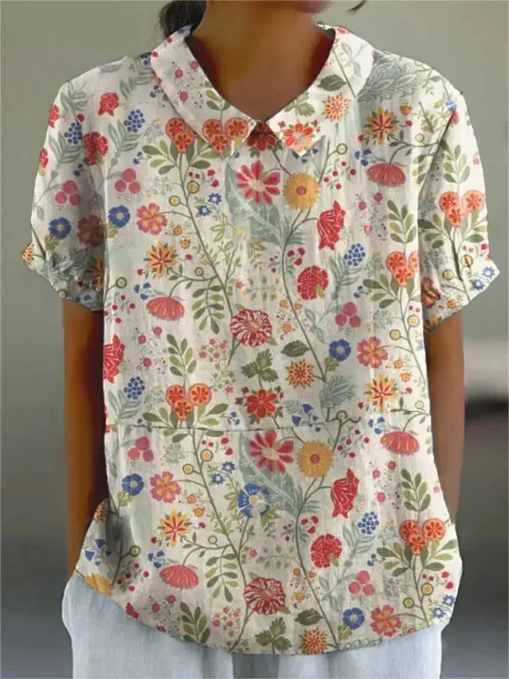 Detail of retro floral embroidery on a women's short sleeve top, vintage charm, collared.