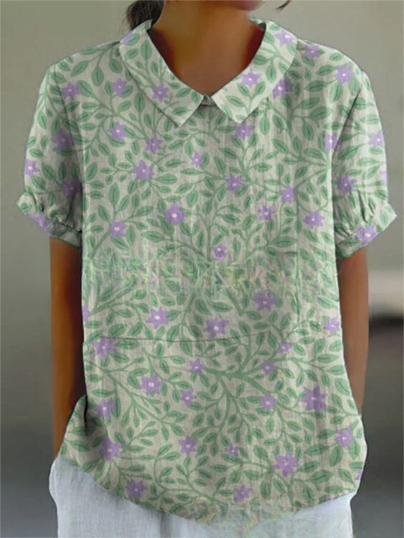 Retro women's top featuring intricate floral embroidery, short sleeve, vintage style.