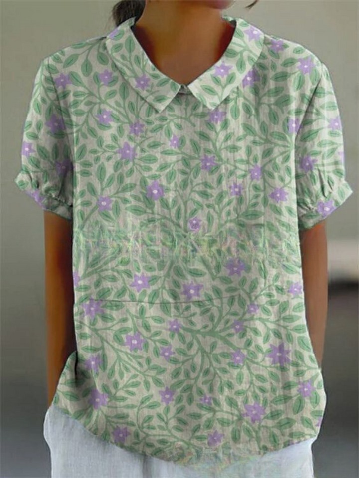 Retro women's top featuring intricate floral embroidery, short sleeve, vintage style.