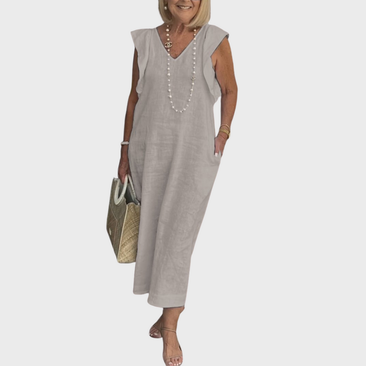 Long women's maxi dress with V-neck, fashionable ruffle shoulders & essential pockets for a stylish look.
