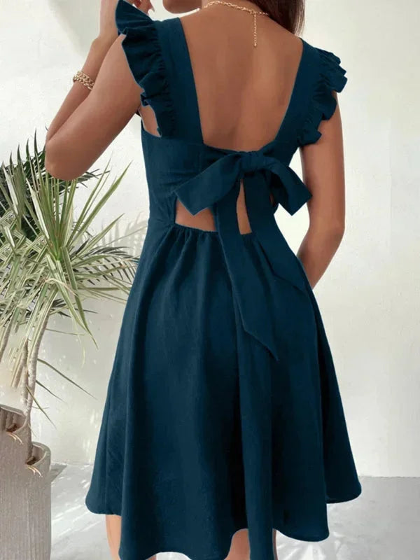 Feminine A-line mini dress with ruffle straps and an eye-catching bow back.
