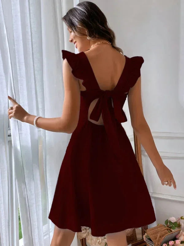 Women's elegant short dress, A-line silhouette, ruffle straps, and a bow back.