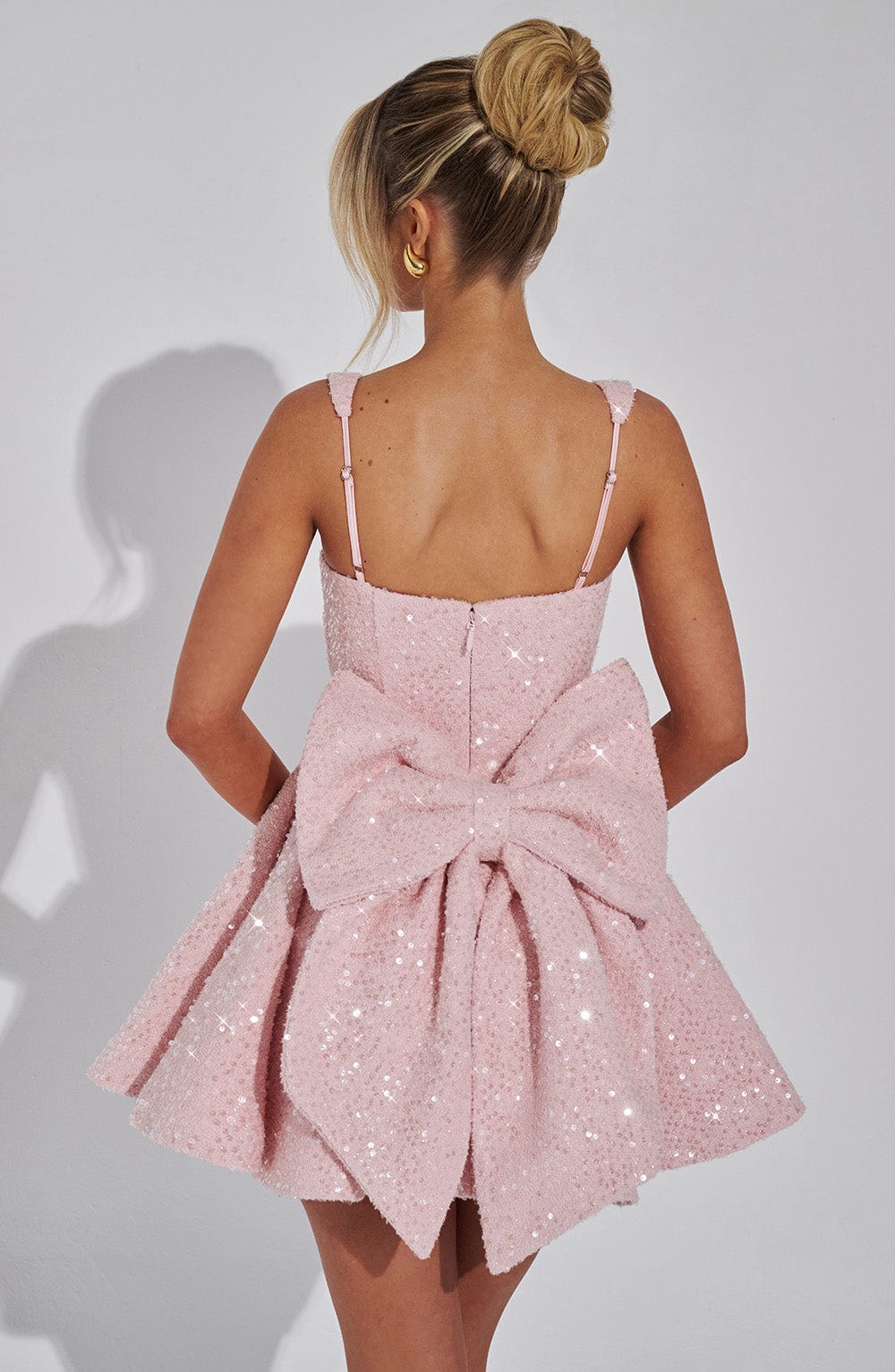 Shimmering sequin mini dress, fit & flare design for women, features a stylish back bow detail.