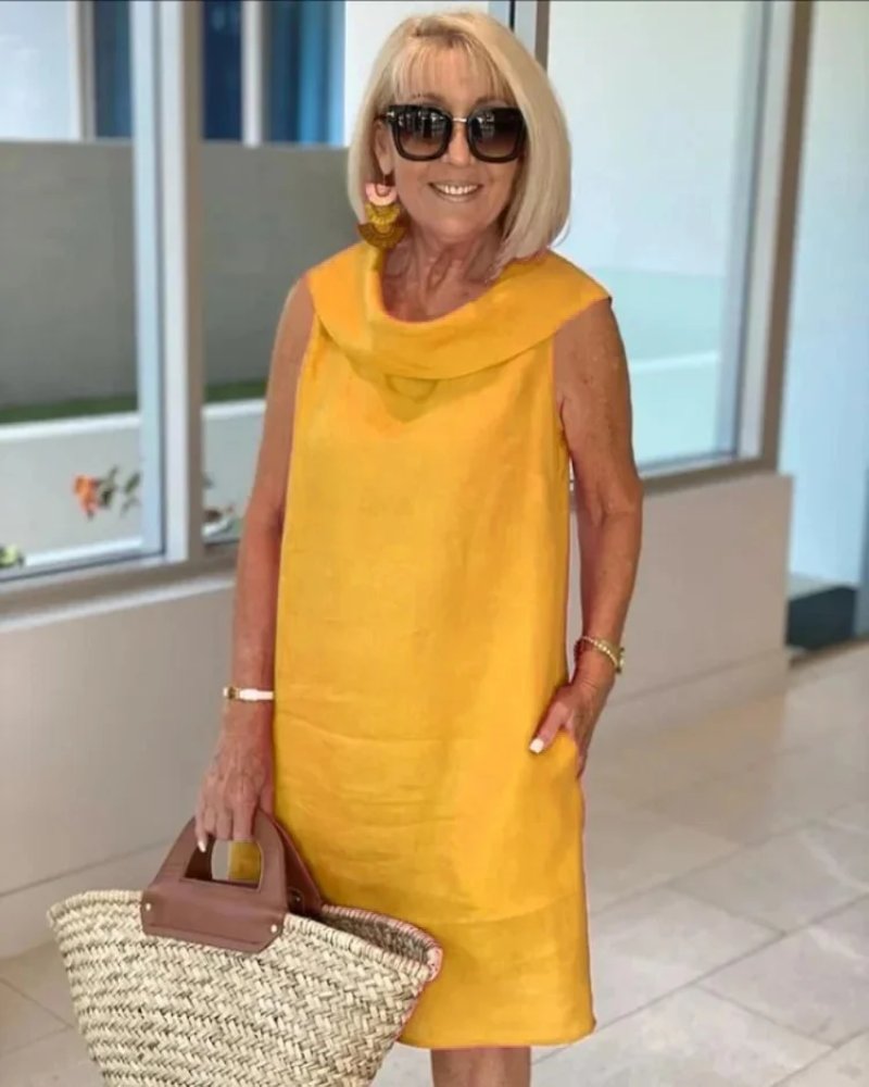 Sleeveless women's shift dress with a flattering cowl neck & pockets. Ideal for summer, offering a relaxed casual fit.