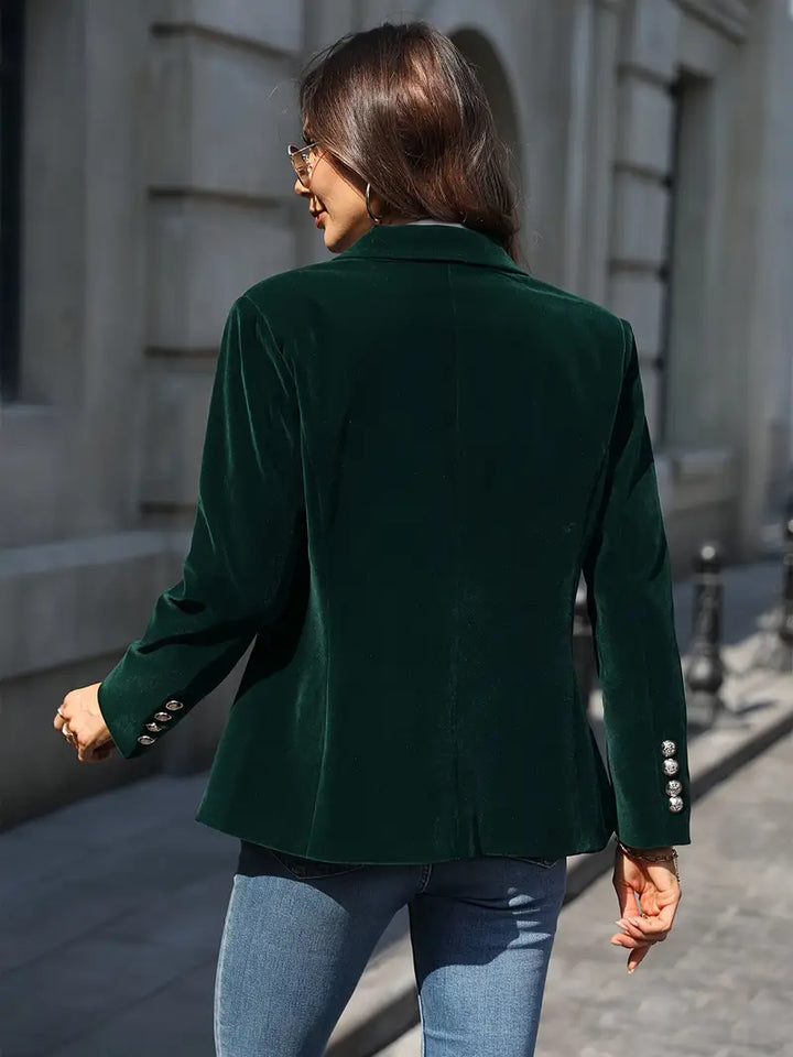 Tailored women's velvet jacket, slim fit, with striking gold button details, very chic.