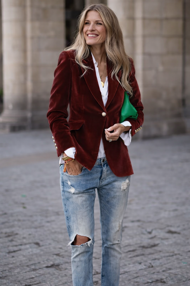 Side view of a women's tailored velvet blazer, showcasing slim fit and gold button cuffs.