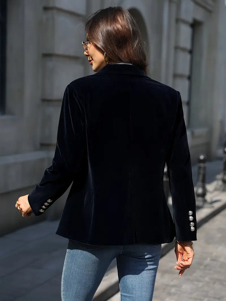 Close-up of a women's velvet blazer showing intricate gold buttons and soft texture.