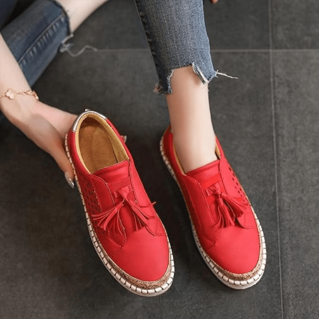 Elegant women's perforated slip-on sneakers, perfect casual footwear with fashionable tassel details.