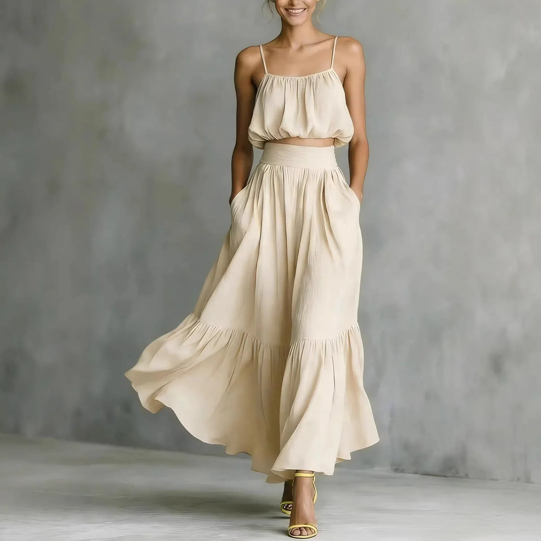 Flowy women's two-piece beachwear set with spaghetti strap crop top and ruffle hem maxi skirt. Vacation style.