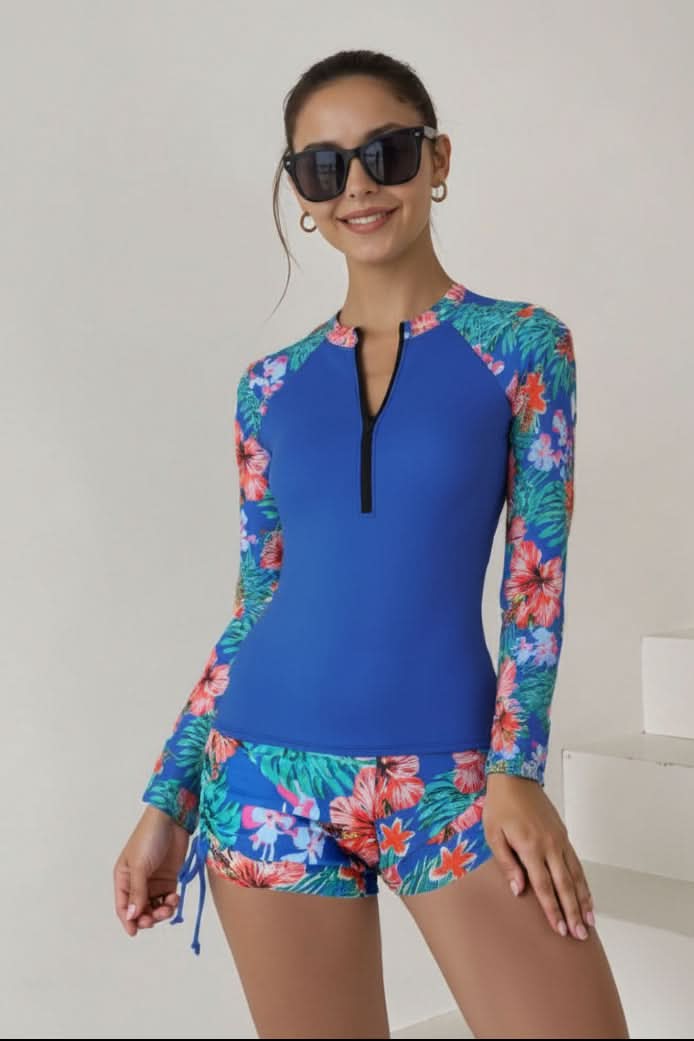 Women's long-sleeve rashguard top and matching bottom, tropical print two-piece for sun-safe swimming.