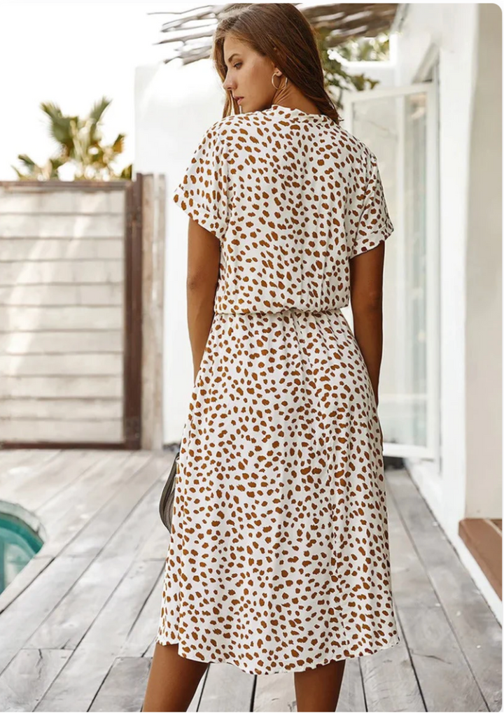 Elegant spotted midi dress, V-neck, button details, and flowy silhouette.
