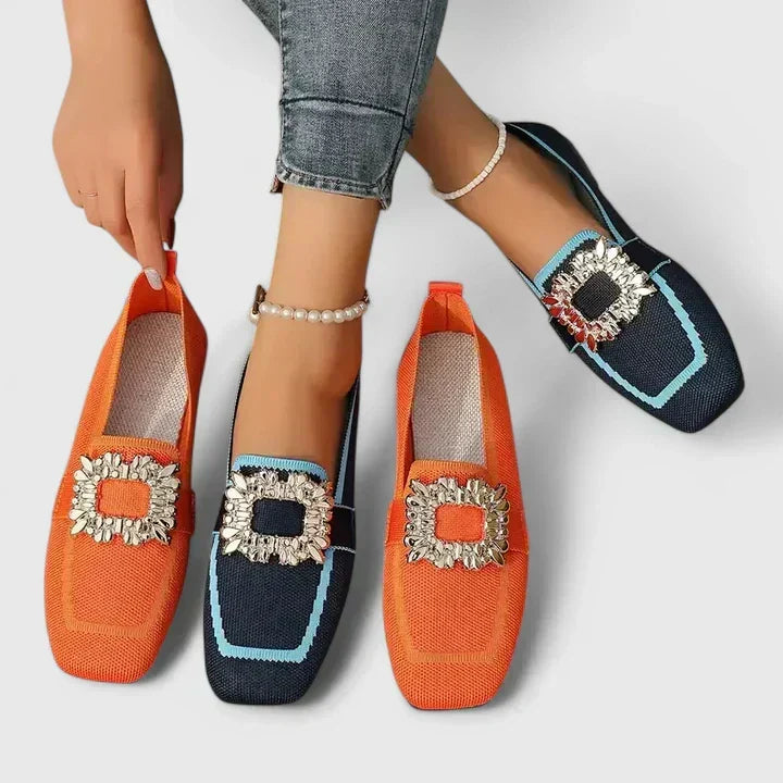 Close-up of women's flat mules featuring a sparkling rhinestone buckle. Chic square toe slip-on shoes.