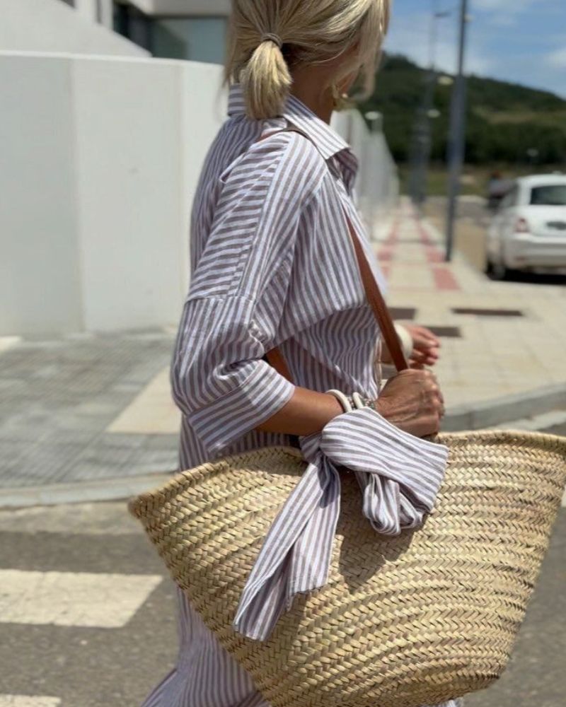 Striped button-up women's midi shirt dress with functional pockets, an essential for spring/summer fashion.