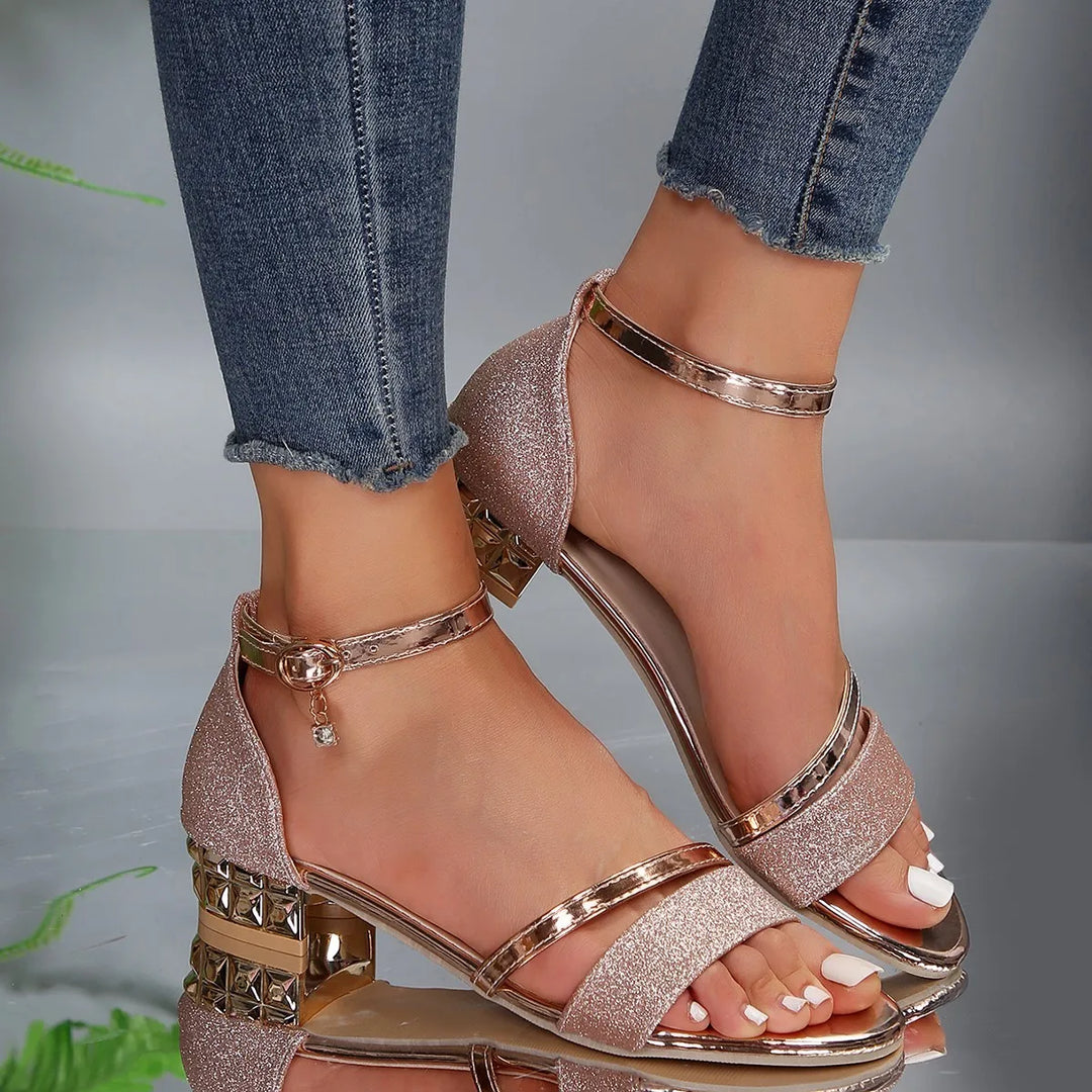 Gold women's heeled sandals featuring a sturdy block heel and adjustable ankle strap.