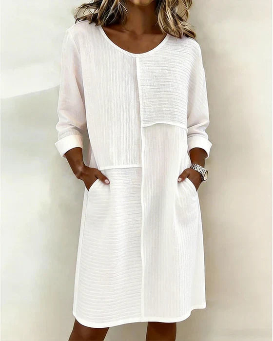 Women's textured shift dress with three-quarter sleeves & pockets. Comfortable & versatile for everyday wear.