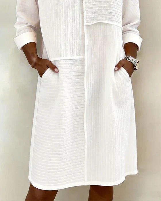 Effortless women's shift dress featuring three-quarter sleeves, practical pockets, and a stylish textured fabric.