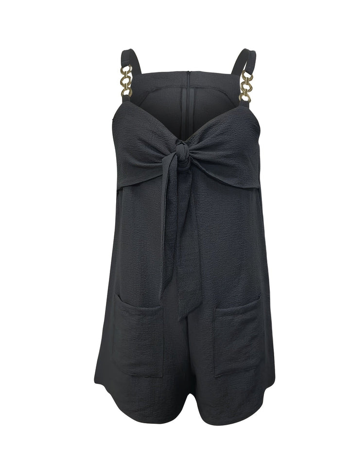 Elegant bow detail on women's textured romper with chain straps, enhancing its casual chic appeal.