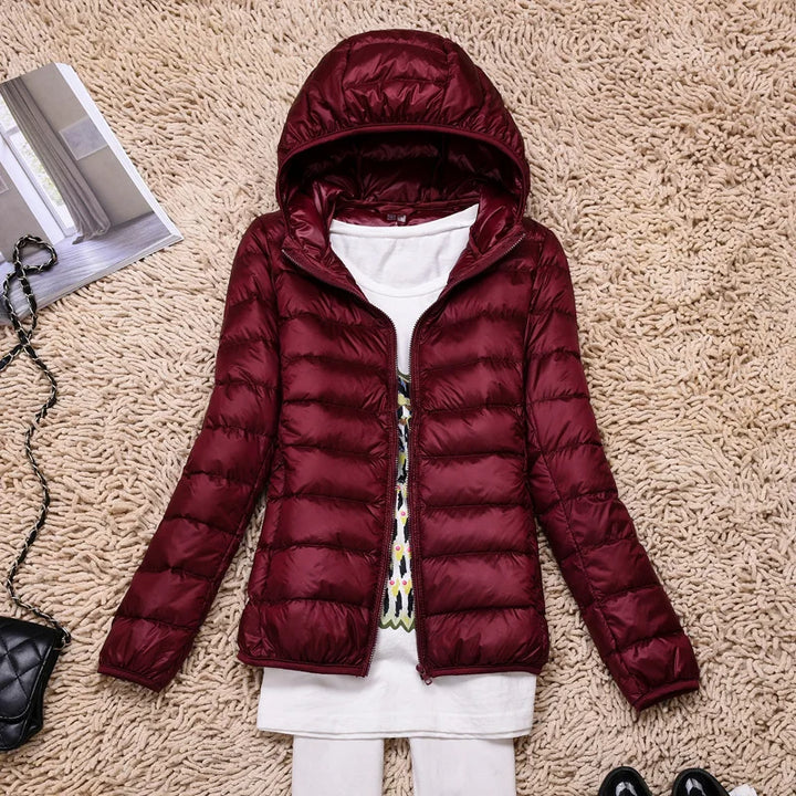 Insulated hooded jacket for women, ultralight design, offering winter warmth and comfort.
