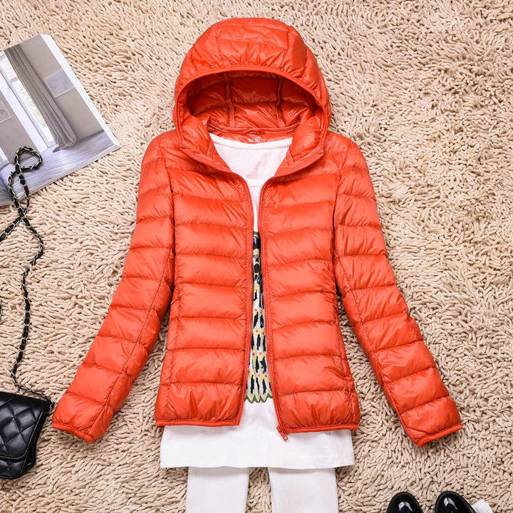Lightweight women's outerwear, hooded & insulated, designed for travel convenience and warmth.