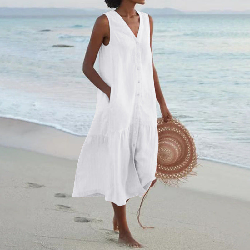 Flowy sleeveless midi dress with V-neck and button front. Ideal for beachwear or vacation fashion.