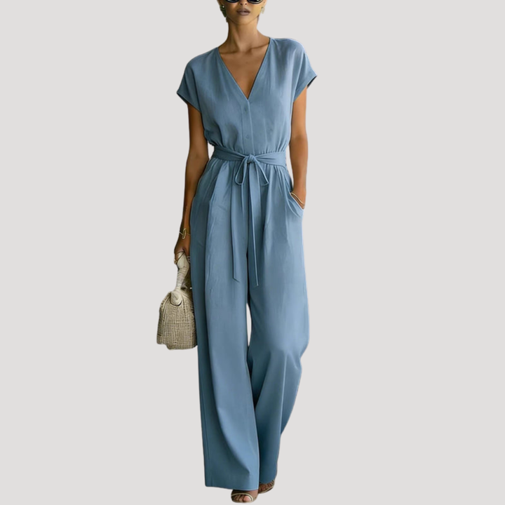 Comfortable women's wide leg jumpsuit featuring V-neck, cap sleeves & tie waist. Versatile for day or night.