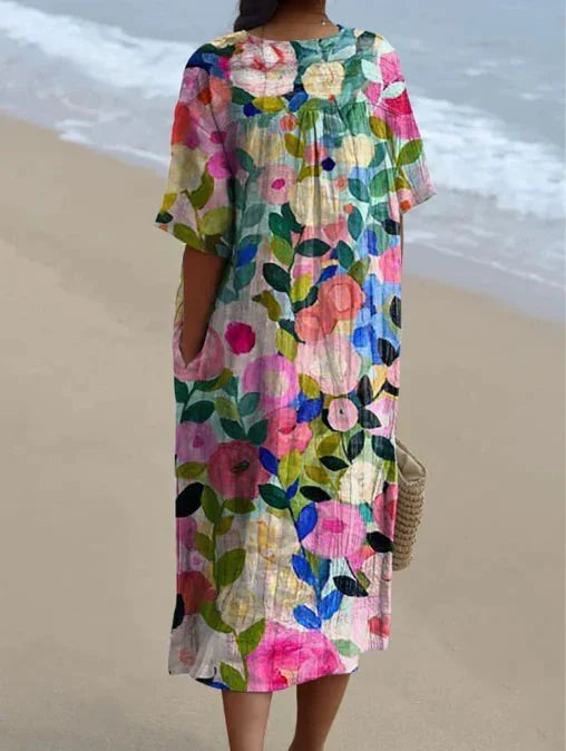 Women's V-neck short sleeve floral midi dress worn in an outdoor, sunny summer setting.