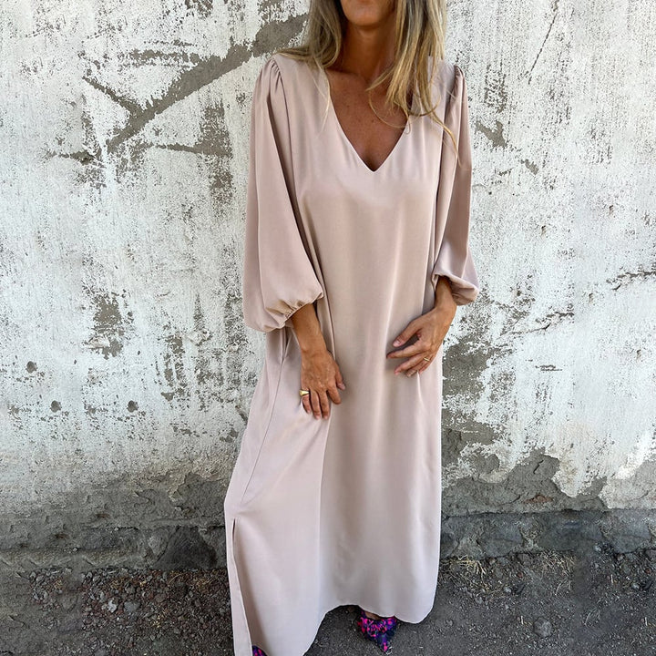 Elegant women's flowy maxi dress. Modest V-neck, stylish balloon sleeves, and useful pockets for a sophisticated casual look.