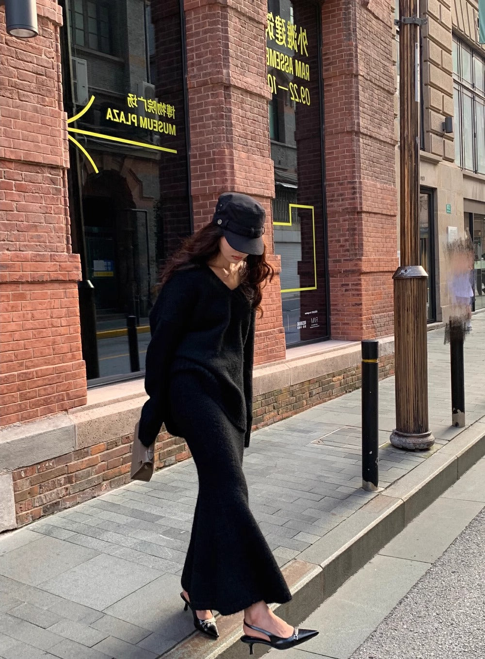 Side view of a fashionable women's V-neck sweater & midi skirt set, a stylish long sleeve brunch outfit.