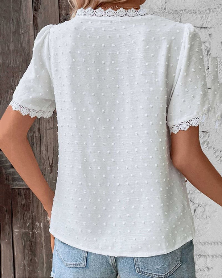 Feminine V-neck Swiss Dot top for women, featuring intricate lace trim & comfortable relaxed fit. Versatile spring wear.