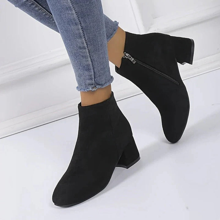 Elegant women's ankle boots feature a sturdy block heel and practical side zip, great for casual outfits.