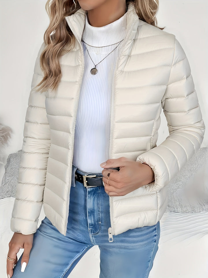 Women's quilted outerwear jacket with a chic stand collar and secure zip closure, blending casual style with warmth.
