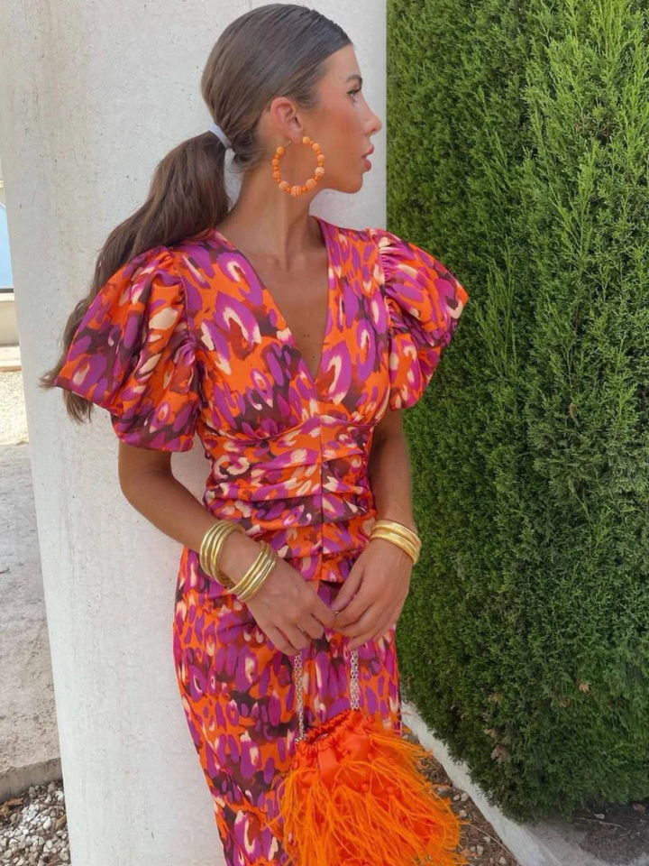 Elegant women's ruched midi dress in a colorful abstract print, ideal for spring and summer evening events.
