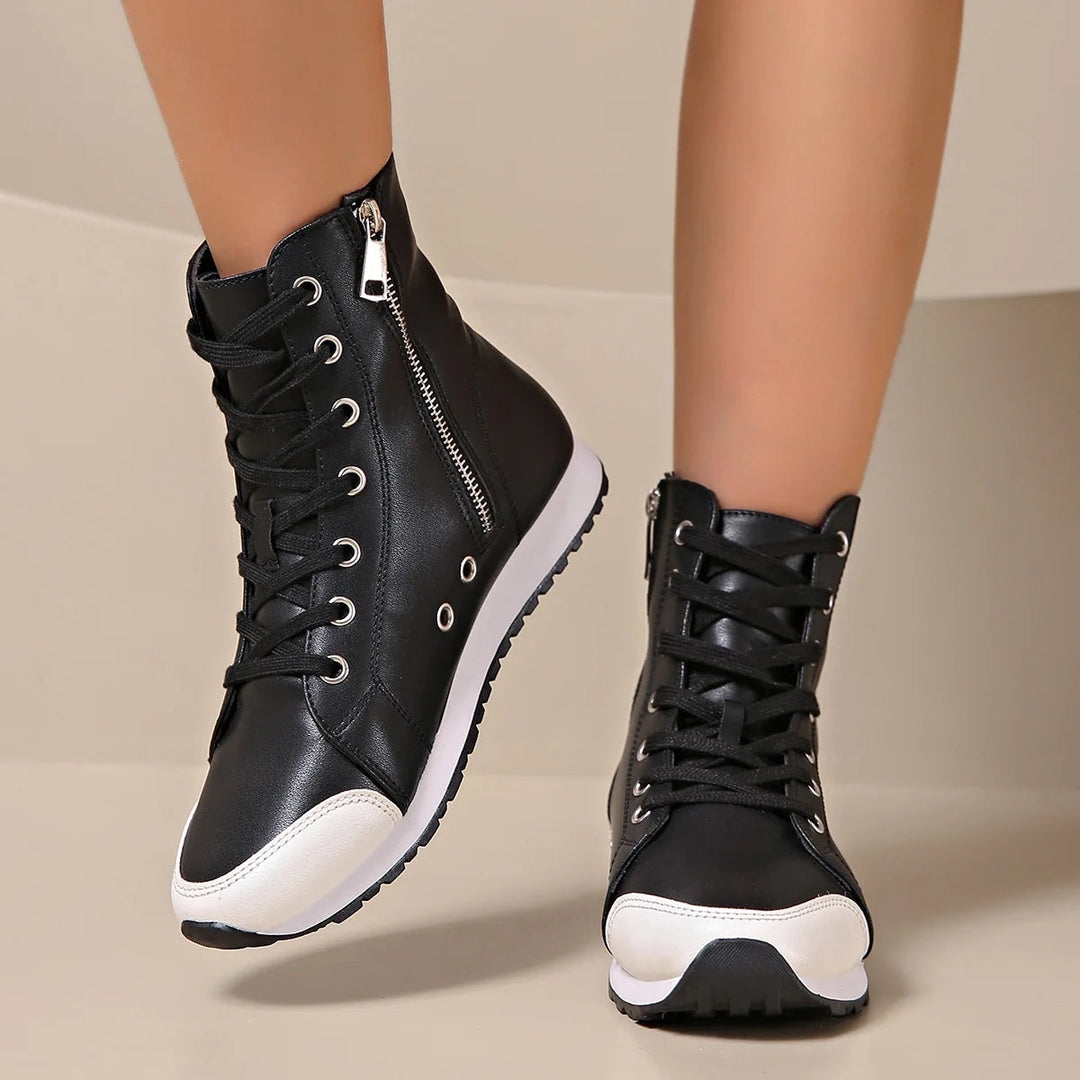 Woman wearing white wide fit orthopedic lace-up sneakers, walking comfortably on a path, designed for foot relief.