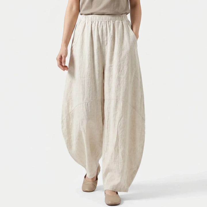 Comfortable women's beige wide-leg flowy pants with an elastic waist. Loose fit trousers for ultimate daily comfort.
