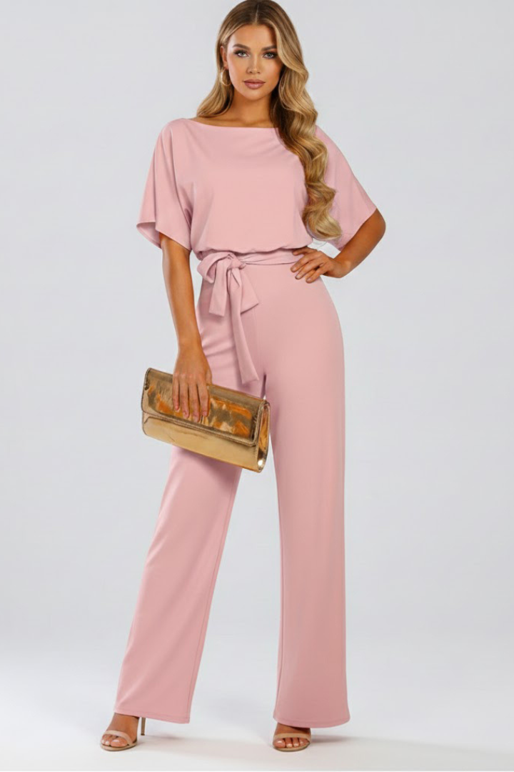 Woman posing in a sophisticated wide leg short sleeve jumpsuit. Belted design, perfect for versatile day to night wear.
