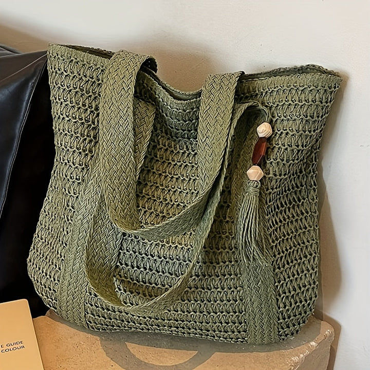 Lightweight woven straw beach tote with a charming fringe tassel, excellent for summer vacations.