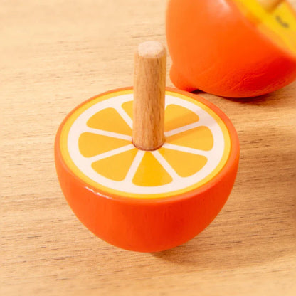 Child's hand spinning a natural wood Montessori fidget toy, enhancing fine motor skills.