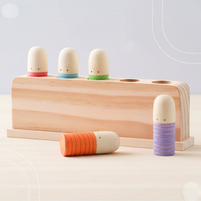 Toddler playing with a wooden sensory toy, developing fine motor skills and hand-eye coordination.