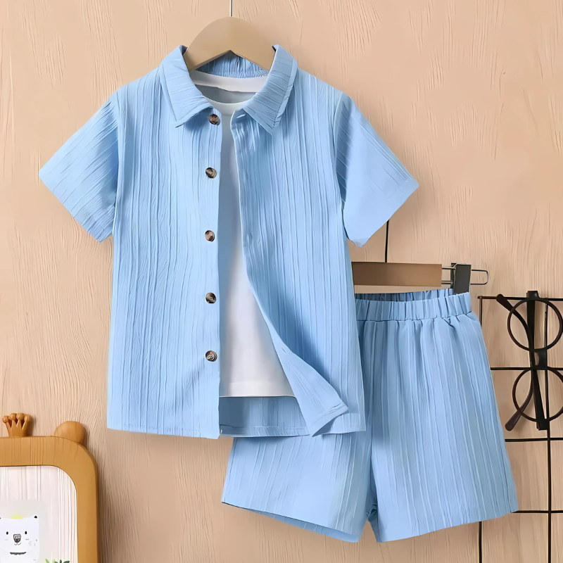 Young boy in blue wave print short sleeve shirt and shorts summer adventure set, breathable playwear.