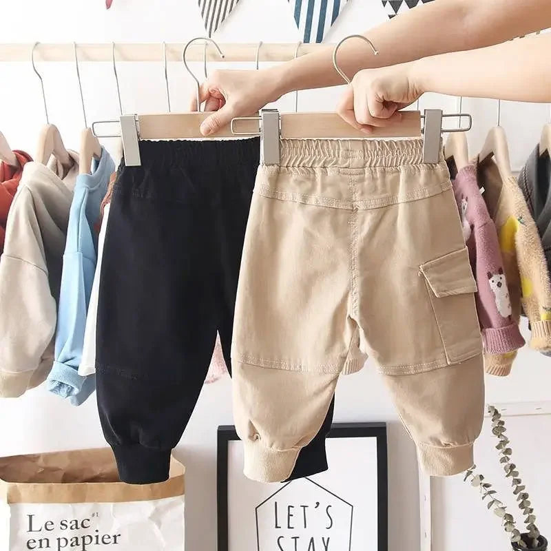 Close-up of durable khaki cargo play pants, showing pocket detail and sturdy stitching