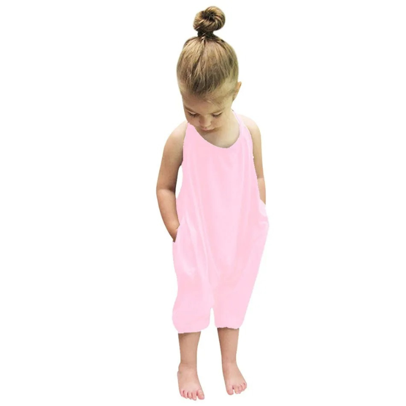 Child playing outdoors in a brightly colored backless harem jumpsuit, essential summer fashion